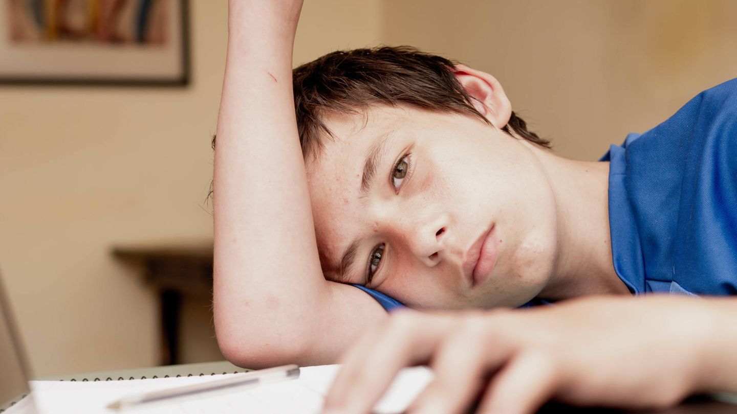 Schüler sitzt alleine lustlos bei den Hausaufgaben