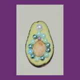 Eine Avokado aufgeschnitten und mit Perlen ausgelegt