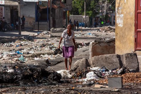 Eine Frau läuft durch eine zerstörte Straße in Haitis Hauptstadt Port-au-Prince