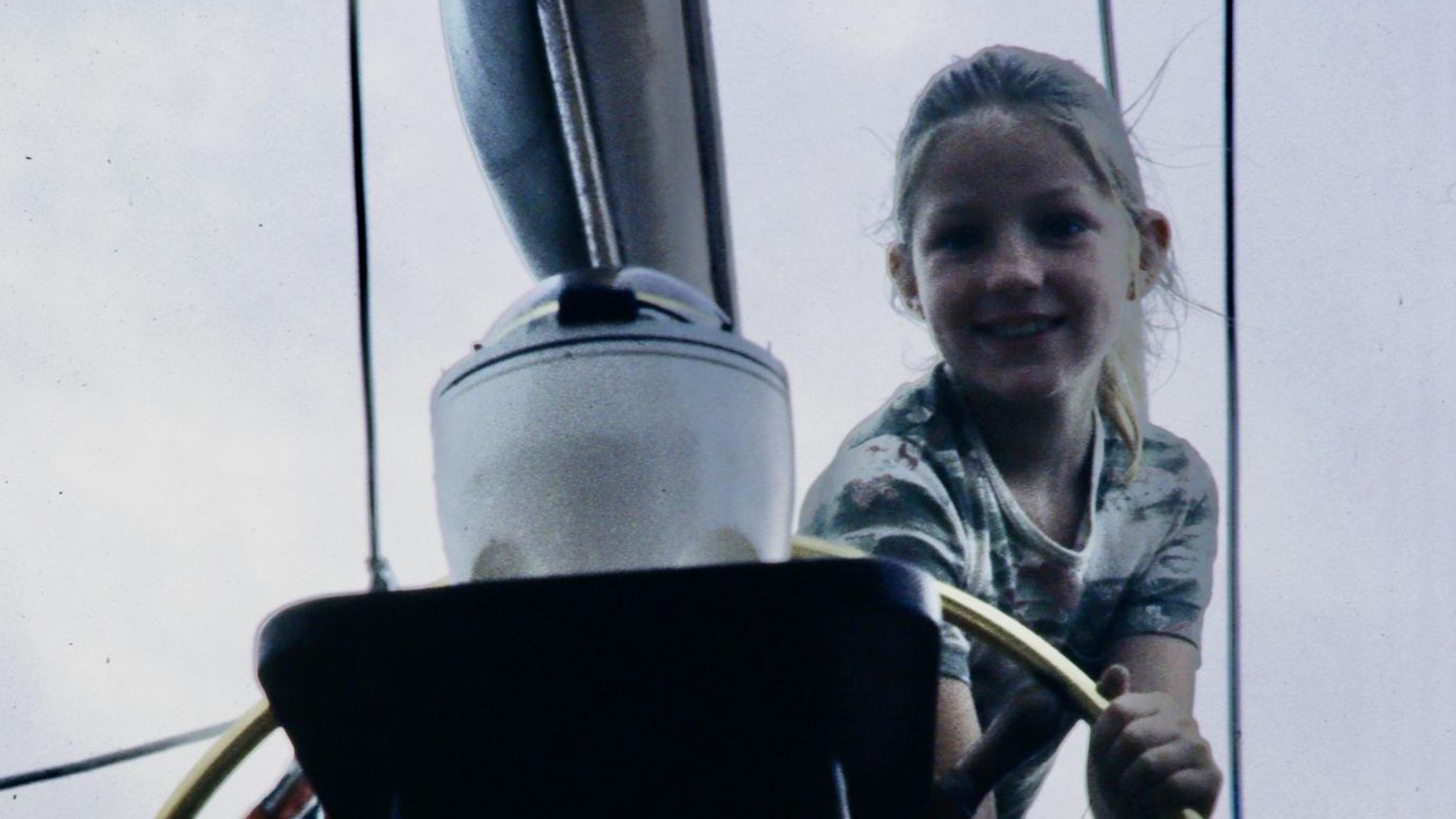 Ein Mädchen (Suzanne Heywood) dreht das große Steuerrad einer Yacht.