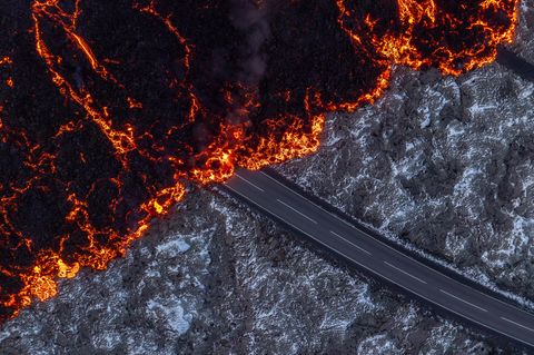 Reykjanes, Island. Aktive Lava fließt auf der Straße zur Blauen Lagune, Grindavik, nach dem Vulkanausbruch, der am Mittwoch begann. Inzwischen hat sie den Parkplatz der Touristenattraktion erreicht.