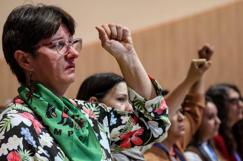 Teilnehmer der Klimakonferenz COP29 in Baku stehen in einem Plenarsaal und fiebern den Ergebnissen entgegen