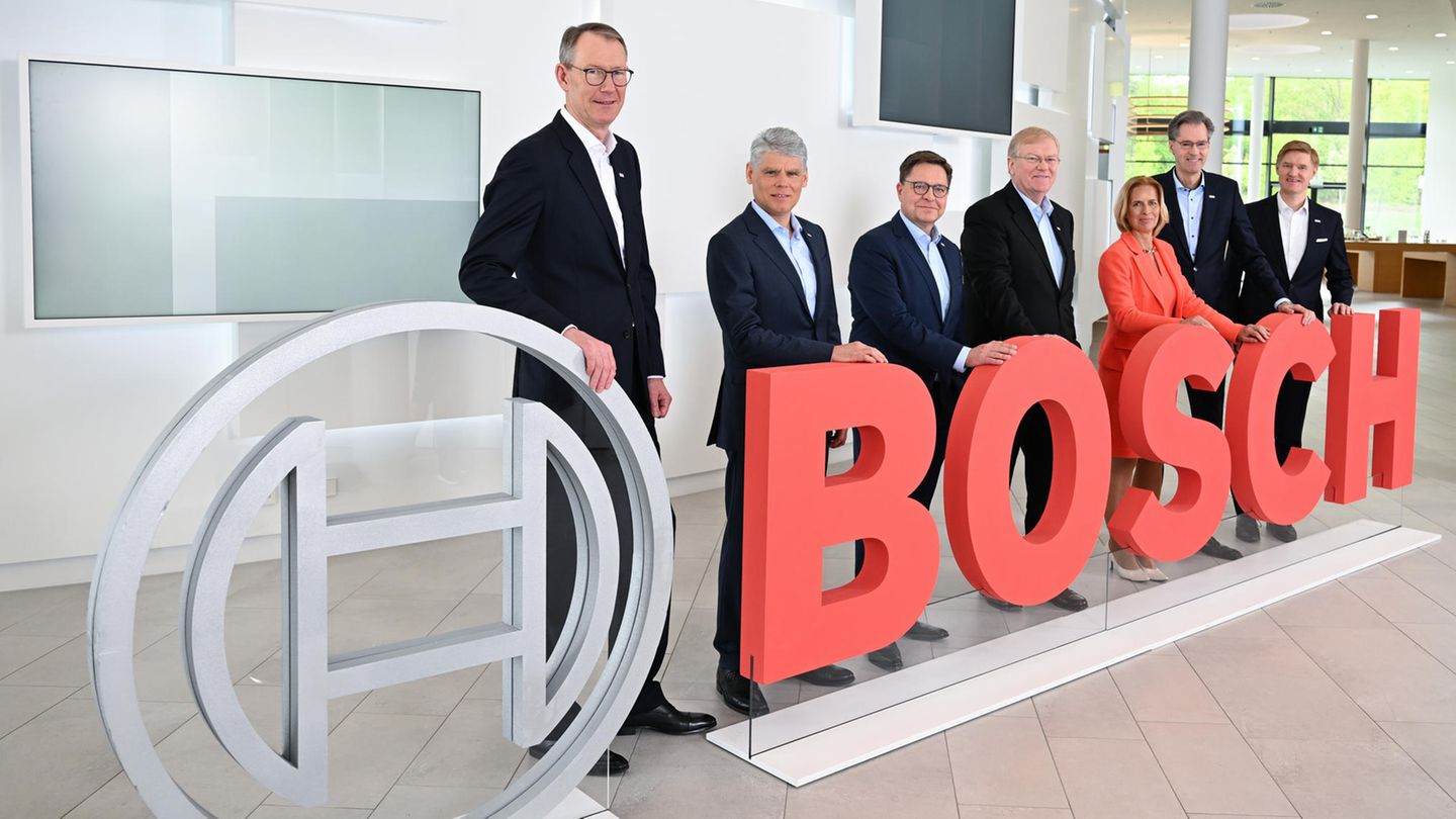 Bosch-Geschäftsführer stehen bei der Bilanz-Pressekonferenz des Konzerns an einem Bosch Logo