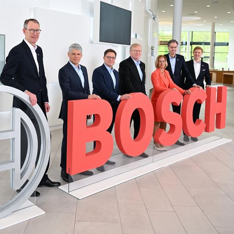 Bosch-Geschäftsführer stehen bei der Bilanz-Pressekonferenz des Konzerns an einem Bosch Logo