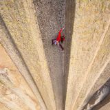 Frau klettert an Felswand