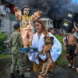 Eine Jugendliche flieht vor dem Feuer mit einer Puppe und einem Hund in den Armen