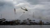 Ein Hubschrauber wirft Wasser über dem Armenviertel ab