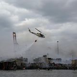 Ein Hubschrauber wirft Wasser über dem Armenviertel ab