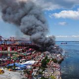 Rauchwolke über der Halbinsel, links das Containerterminal, rechts Wasser