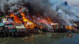 Große hellrote Flammen fressen sich durch die Hütten
