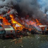 Große hellrote Flammen fressen sich durch die Hütten
