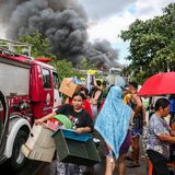 Leute tragen auf ihren Armen Kartons, Schubladen und andere Gegenstände aus dem Viertel heraus