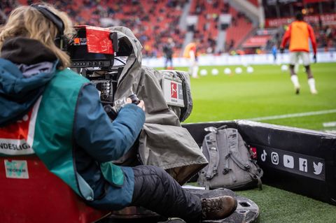 Eine TV-Frau filmt in einem Bundesliga-Stadion