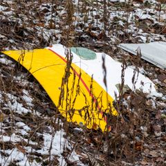 Ein zum Teil DHL-gelb lackiertes Trümmerteil liegt an der Absturzstelle