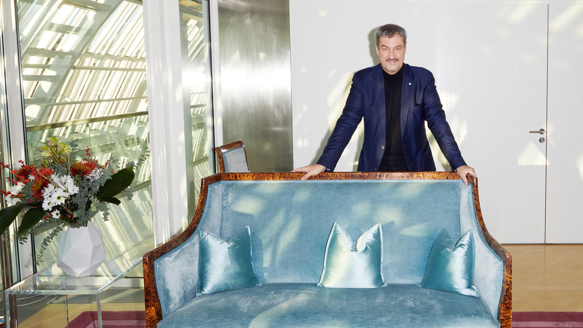 Markus Söder steht hinter einem Sofa in der bayerischen Staatskanzlei