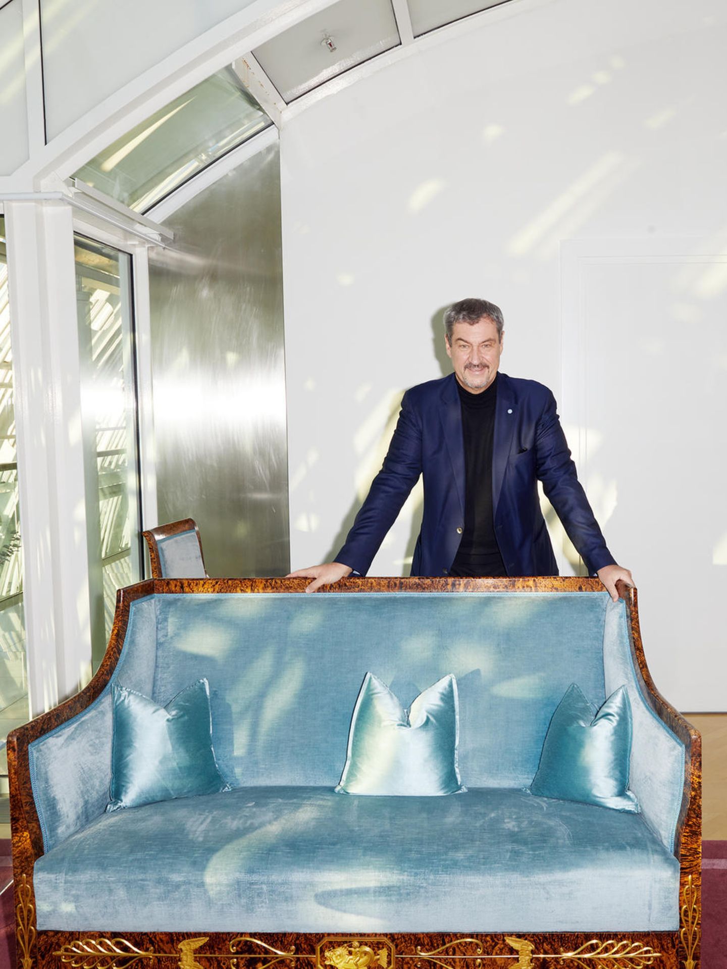Markus Söder steht hinter einem Sofa in der bayerischen Staatskanzlei