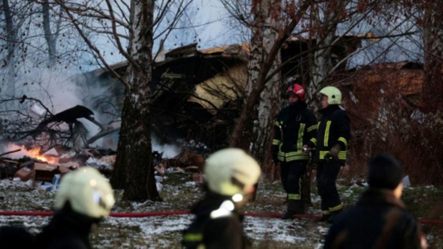 Feuerwehrleute am Wrack des Flugzeugs