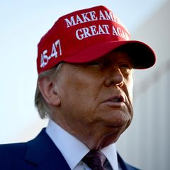 Donald Trump trägt ein rotes Cap mit "Make America great again"-Stick
