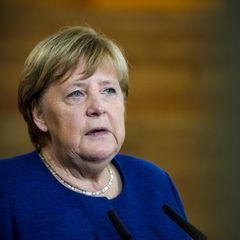 Angela Merkel sitzt auf einer Bühne, ihr neues Buch sorgt für Aufsehen