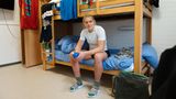 Spitzensport junge Frau sitzt im unteren Stockbett