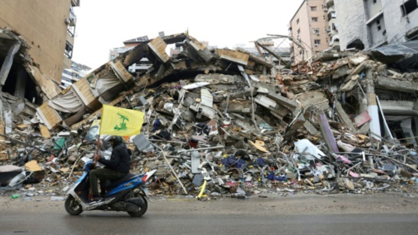Hisbollah-Anhänger vor zerstörtem Gebäude in Südbeirut