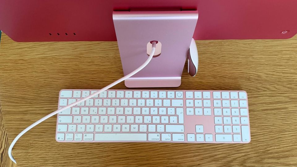 Hinter einem iMac liegen Tastatur und Maus in derselben Farbe Hinter einem iMac liegen Tastatur und Maus in derselben Farbe