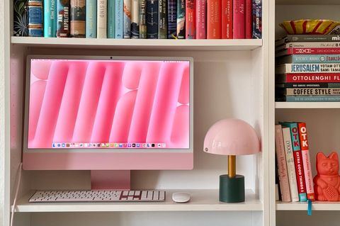 Ein Apple iMac steht in einem schick eingerichteten Regal