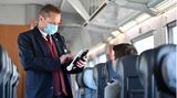 Ein Zugbegleiter der Deutschen Bahn bei der Fahrkartenkontrolle