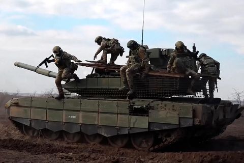 Russische Soldaten springen von einem Panzer