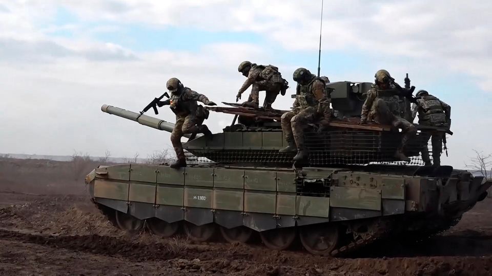 Russische Soldaten springen von einem Panzer