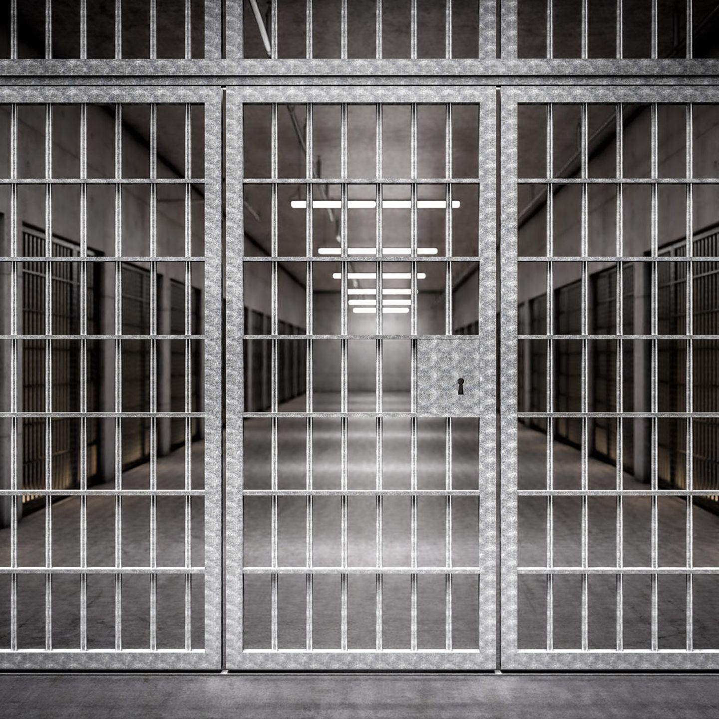 Blick durch eine Gittertür in einen Gefängnisflur