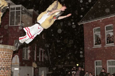 Mit Masken verkleidete Männer des Vereins Borkumer Jungens ziehen in der Nacht vor Nikolaus durch die Straßen der Nordseeinsel