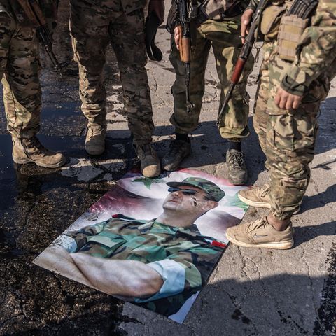 Rebellen nutzen ein Plakat von Syriens Diktator Baschar al-Assad als Fußabstreifer