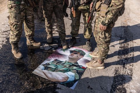 Rebellen nutzen ein Plakat von Syriens Diktator Baschar al-Assad als Fußabstreifer