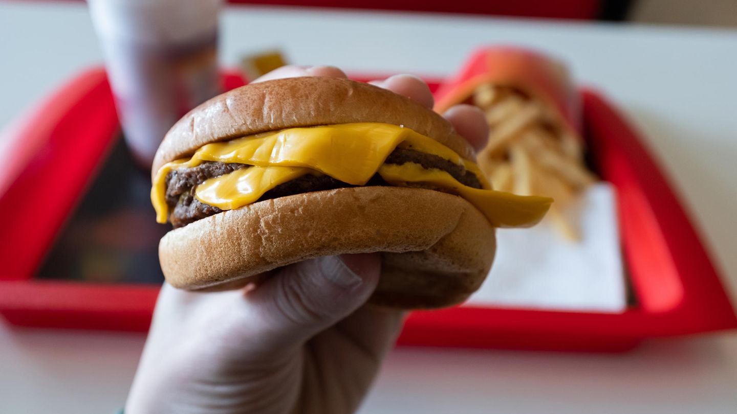 Ein Hand hält einen Hamburger Ein Hand hält einen Hamburger