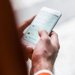 Eine Person hält ein Handy in der Hand und hat Whatsapp offen