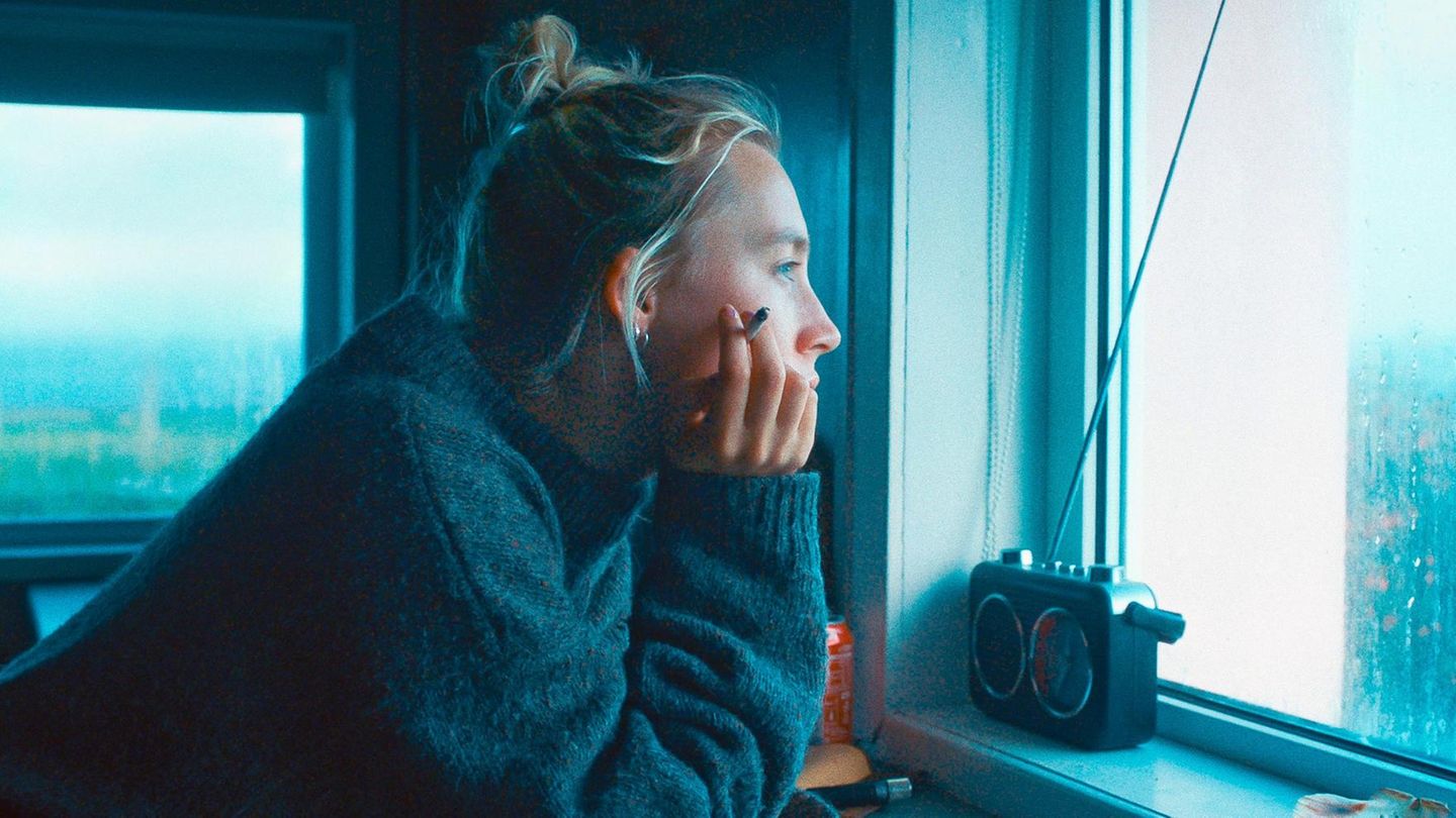Pressefoto Filmszene Rona:  Saoirse Ronan schaut mit einer Zigarette in der Hand aus dem Fenster