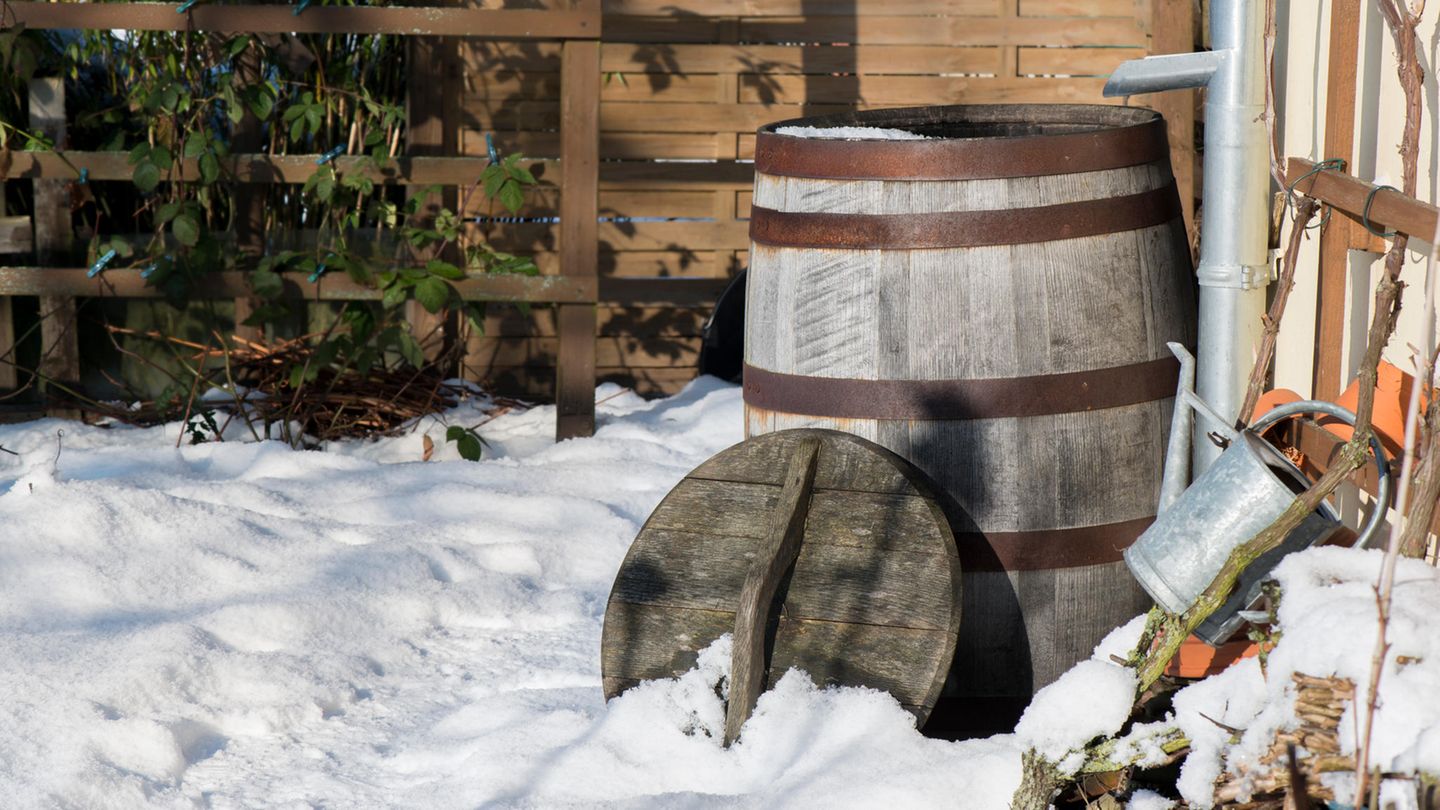 Eine Regentonne steht im Schnee