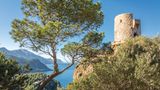Der alte Wachturm auf der Bergspitze, im Hintergrund die Küste und das tieflblaue Meer