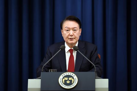 Südkoreas Staatschef Yoon Suk Yeol hält in Anzug und dunkelroter Krawatte eine Rede im TV