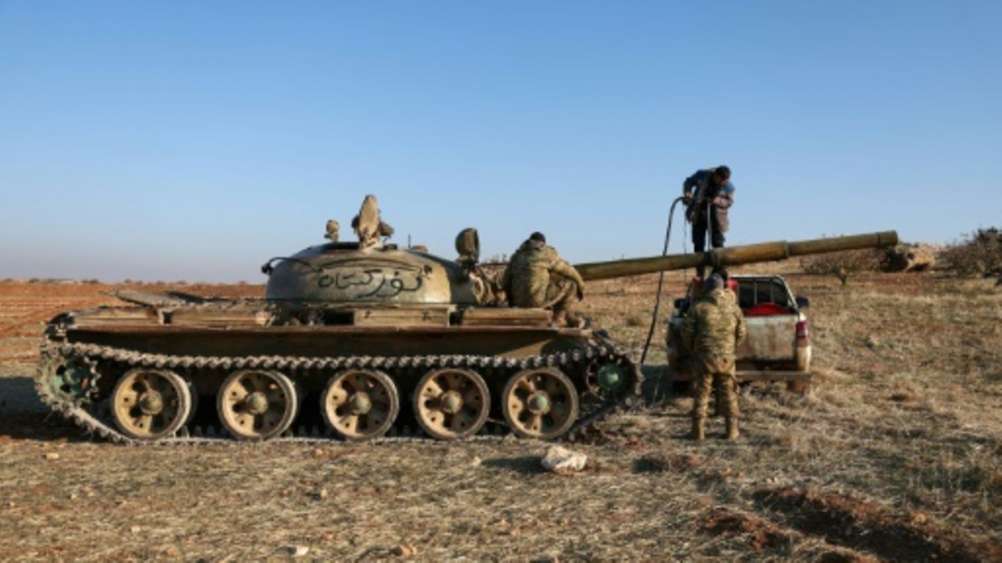 Kämpfer nehmen einen Panzer des syrischen Militärs ein