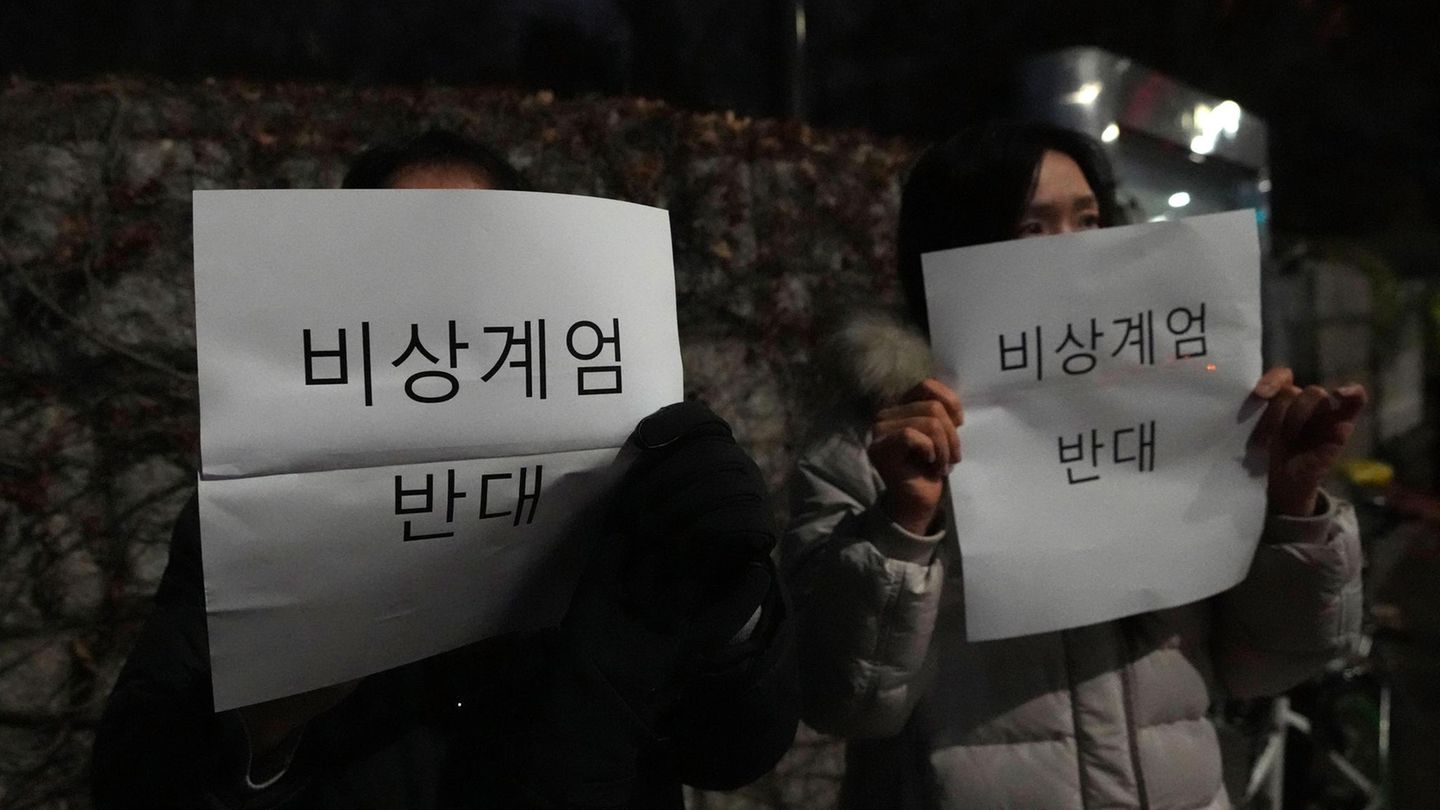 Menschen tragen Schilder mit der Aufschrift "Gegen das Kriegsrecht" vor der Nationalversammlung in Seoul