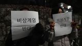 Menschen tragen Schilder mit der Aufschrift "Gegen das Kriegsrecht" vor der Nationalversammlung in Seoul