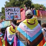 Menschen mit Regenbogenflagge feiern den Christopher-Street-Day in Hamburg
