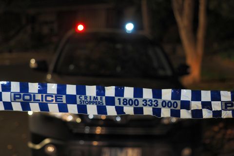 In Australien hängt ein Absperrband der Polizei im Dunkeln über eine Straße