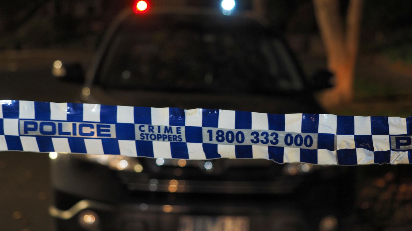In Australien hängt ein Absperrband der Polizei im Dunkeln über eine Straße