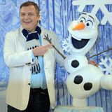 Kerkeling im weißen Jackett nebem dem Schneemann Olaf aus dem Film "Die Eiskönigin"