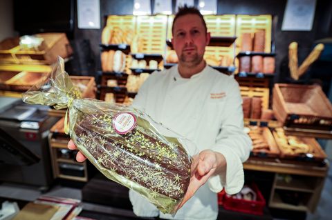 Bäckermeister Andreas Hermisch aus Paderborn hält den fertigen Dubai-Stollen in den Händen. Foto: Christoph Reichwein/dpa