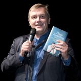 Hape Kerkeling hält eine Buch in der Hand, seine Autobiografie "Der Junge muss an die frische Luft"