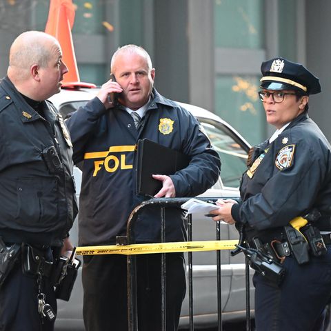 Nach dem Attentat auf Brian Thompson in New York stehen Polizisten an einer Absperrung zum Tatort